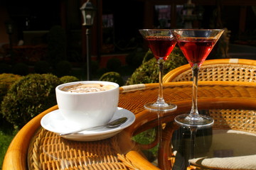 cup of coffee with cream and two glasses with liqueur