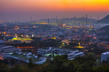 Fototapeta na wymiar Petrochemical plant in the twilight time at Leamchabung Industrial Estate in Thailand that looking from the mountain and shooting by Telephoto lens.