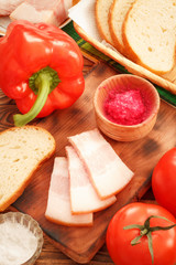 Breakfast with jowl pork bacon, red horseradish sauce, bread, pepper and tomatoes vegetables