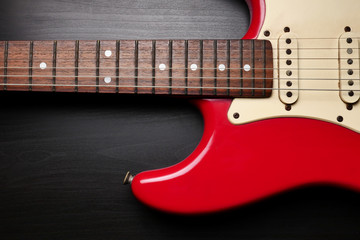 Close up of Electric guitar body and neck detail on black background.
