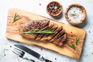Grilled beef striploin steak with red wine glass.