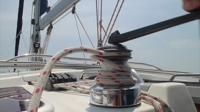 Man on yacht working with winch
