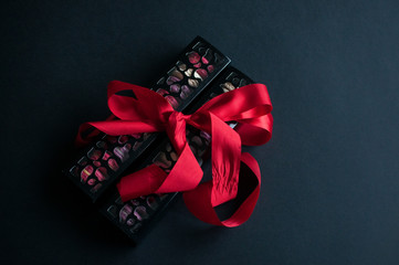macaroon on black background with red ribbon, colorful almond cookies, pastel colors. Preathent with love. St.Valentines day