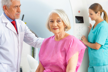 Fototapeta premium Elderly woman undergoing x-ray assisted by doctors