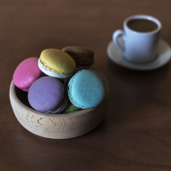 Macaroons in a bowl  and cup of coffee on the table