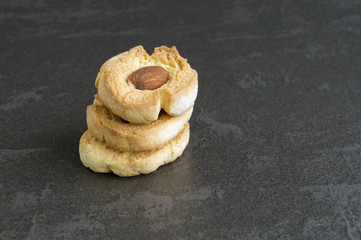 Homemade cookies with almonds on a dark background.