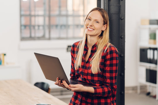 Smiling happy woman holding an open laptop