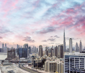 Downtown Dubai at sunset from city river, aerial view
