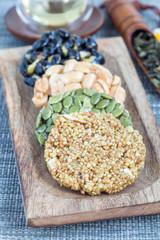 Korean traditional sweet snacks with peanuts, pumpkin seeds, black soybeans and chinese buckwheat on wooden plate, vertical