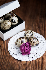 Gift box, qual eggs and dry rose on rustic wooden background