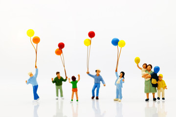 Miniature people, family and children enjoy with colorful balloons, happy family day concept.