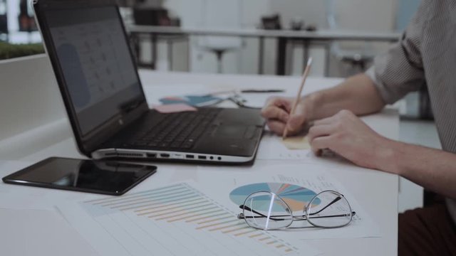 Young Professional Working On Laptop With Pie Chart
