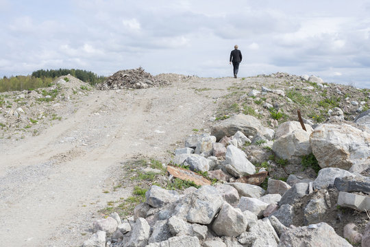 Man in suit walking on dirt road in natural scenery
