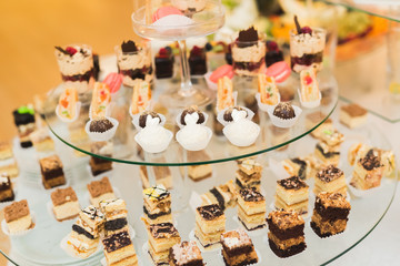 Delicious sweets on wedding candy buffet with desserts, cupcakes