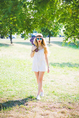 Young beautiful woman outdoor city park walking holding ukulele - musician, composer, busker concept