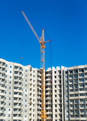 Fototapeta na wymiar Tall cranes and multistorey housing under construction