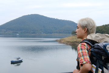 traveler man with backpack travel at mountain & lake. tourist backpacker enjoying view. lifestyle, summer vacation concept