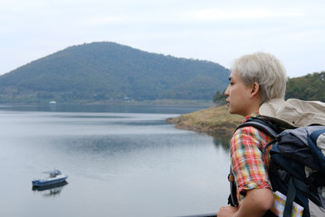 Fototapeta premium traveler man with backpack travel at mountain & lake. tourist backpacker enjoying view. lifestyle, summer vacation concept