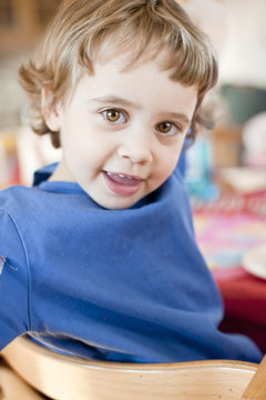 Portrait of little blonde boy sitting on chair