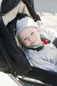 Portrait of baby boy sitting in stroller
