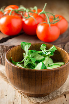 Green salad with spinach, susumber and ripe tomatos on background.