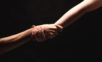 Hands of man and woman in love, isolated on black