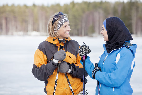 Two female skiers talking outdoors
