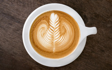 Hot coffee cappuccino latte art top view on wooden background