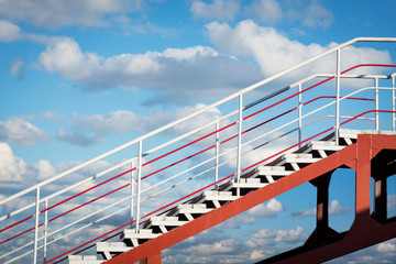 stairs up on the background of blue sky with clouds