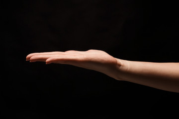 Woman holding palm open isolated on black