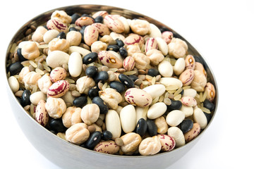 Close up uncooked assorted legumes in metal bowl isolated on white background.