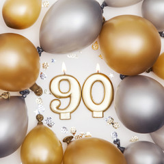Birthday celebration number 90 candle with gold and silver balloons