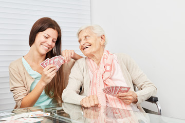 Junge Frau und Seniorin beim Karten spielen