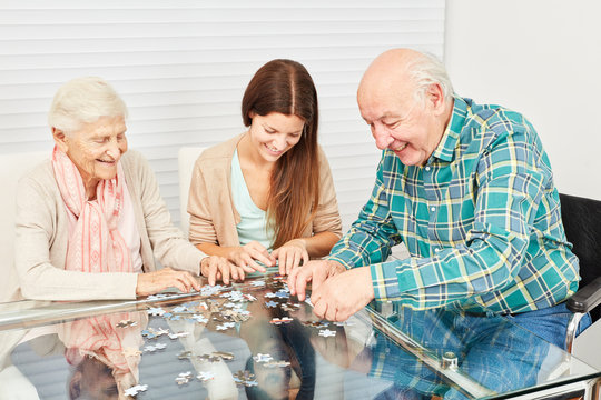 Senioren und Enkeltochter beim Puzzle spielen