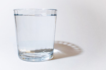One glass of water on white with shadow