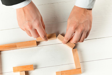 Man and wooden cubes on table. Management concept