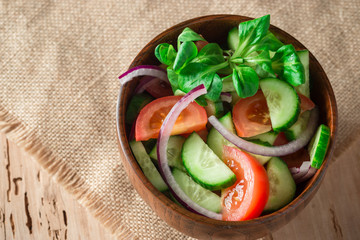 Top view of green fresh salad tomatos onion and cucumber