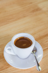 Cup of an espresso coffee on a wooden table