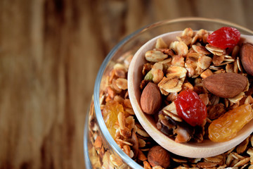 Granola in a glass jar and a wooden spoon. Rustic style