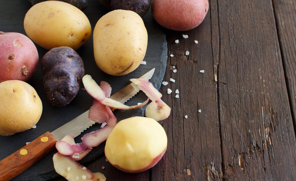 Raw potatoes with a vegetable peeler
