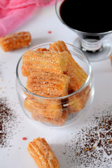 Spanish cookies Churros in a glass jar and chocolate sauce