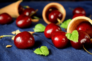 Waffle cones and cherries on blue background. Ingredients for a dessert cooking