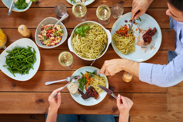 couple at table with food eating pasta and chicken