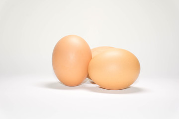 Three chicken eggs on a white background.
