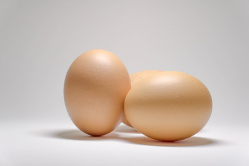 three chicken eggs on a white background.