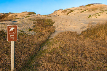 Beach Path and Sign:  A park sign directs hikers across the sand dunes at Cape Hatteras National...