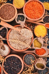 Set of Groats and Grains. Buckwheat, lentils, rice, millet, barley, corn, black rice. On a blue wooden  background. Top view. Copy space.