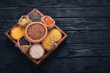 A set of cereals and grains in a wooden basket on a wooden background. Top view. Copy space.