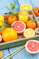 Different fruits and glass with fresh orange juice, wooden background