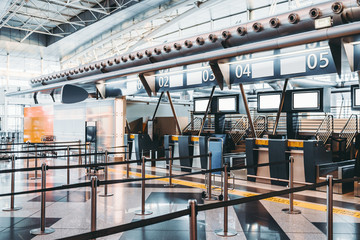 Moderne incheckzone van de luchthaven: terminals voor het accepteren van bagage met transportbandsystemen voor bagageafhandeling, talloze lege mockups op het LCD-scherm met informatie, geïndexeerde incheckbalies met cijfers erboven